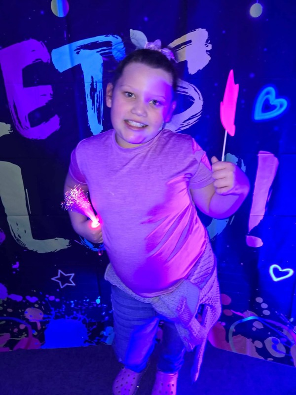 Students in glow party photo booth.