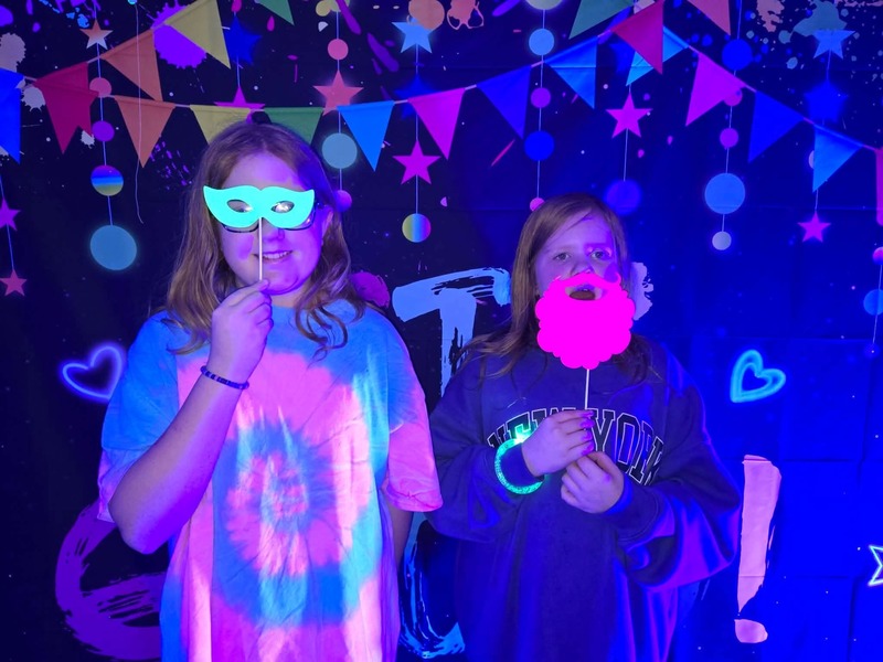 Students in glow party photo booth.