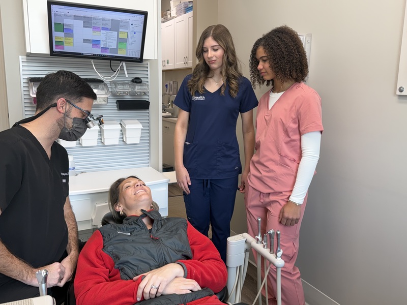 Two students learning from a dentist.