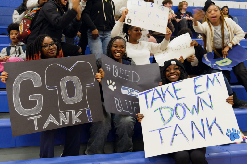 Students holding signs supporting tank for the Super Bowl.