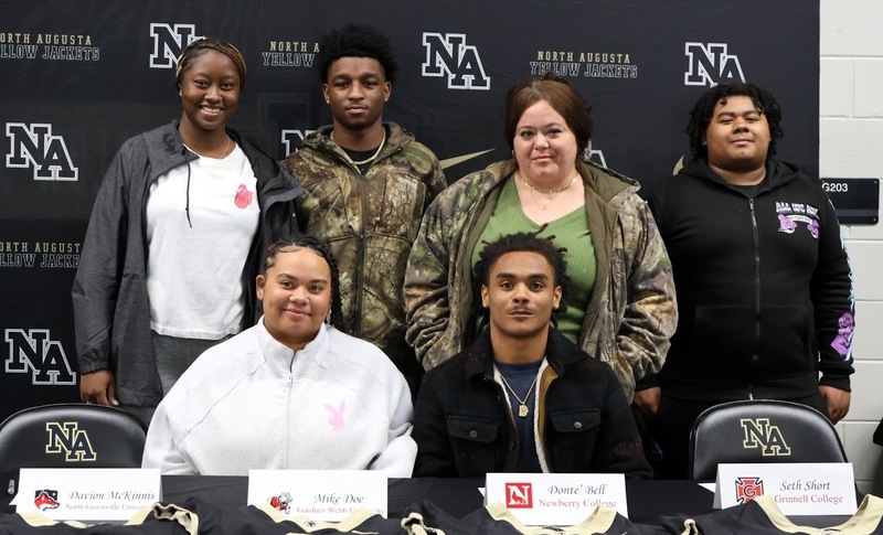 Football player surrounded by family.