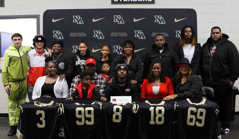 Family surrounding player at signing. 