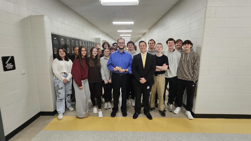 Teacher, principal and students standing in hallway.