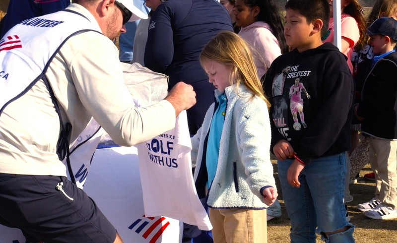 Girl gets sized with free white branded T-Shirt.