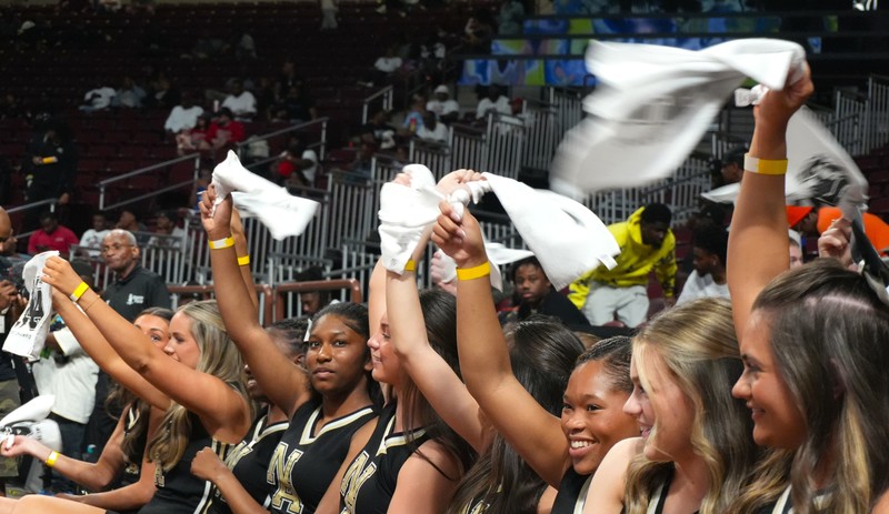 Cheerleaders swing rally towels.