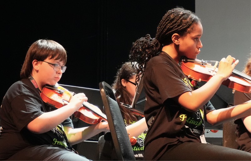 Violin players play their instruments.