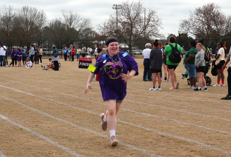 Student runs in short distance track event.