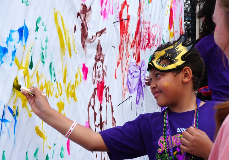 A boy paints a mural. 