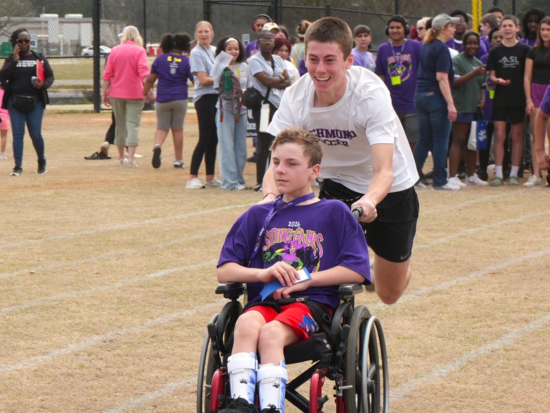 Student runs with a wheelchair student.