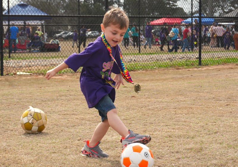 A boy kicks a soccer ball.