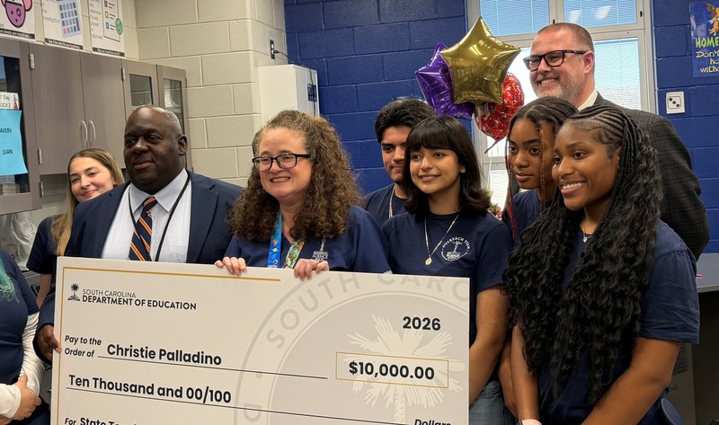 Dr. Palladino holding a check for $10,000.