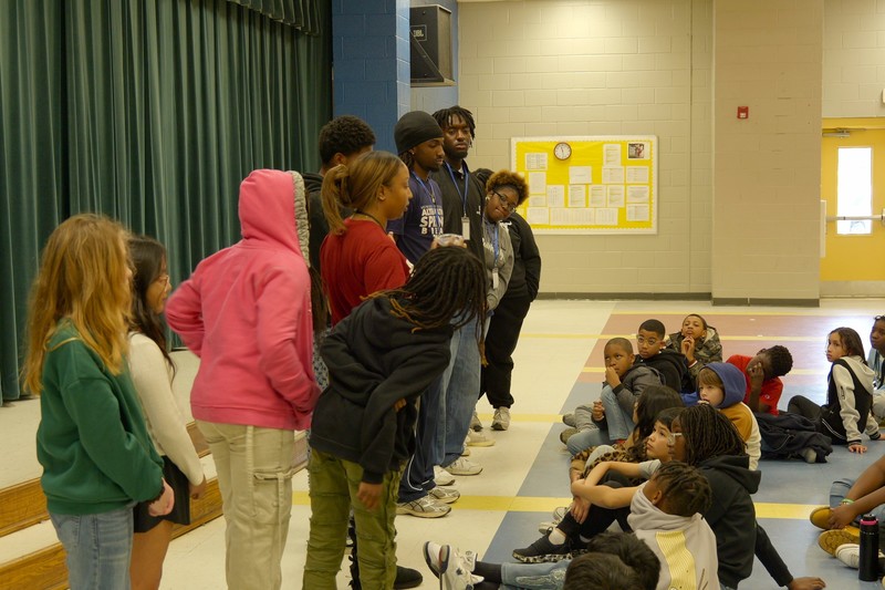 Howard students talking to large group of students.