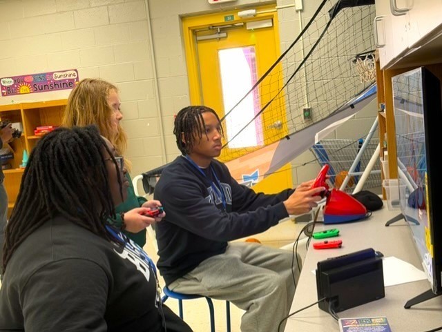 Howard student playing video game with student.