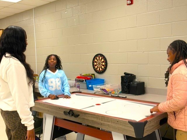 Students at disc hockey table.