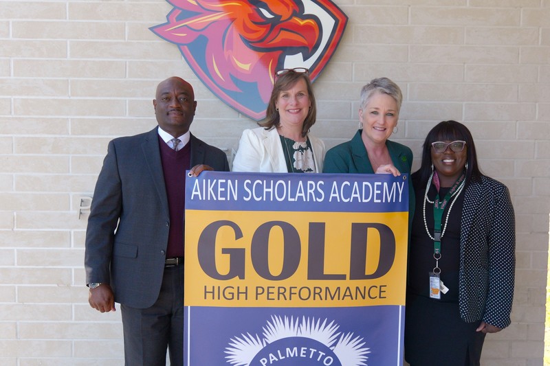 District leadership stands outside Aiken Scholars Academy.
