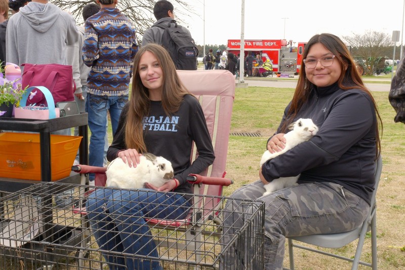 Two students holding rabbits posing for picture.
