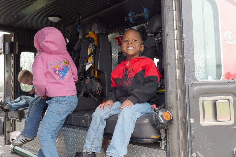 Student sitting in fire struck posing for photo.