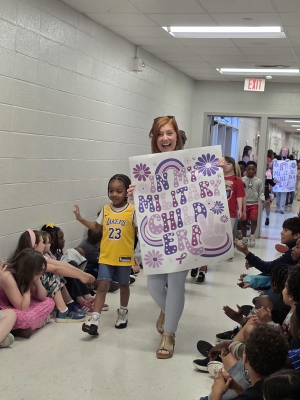 Students and staff walking through the hall in parade.