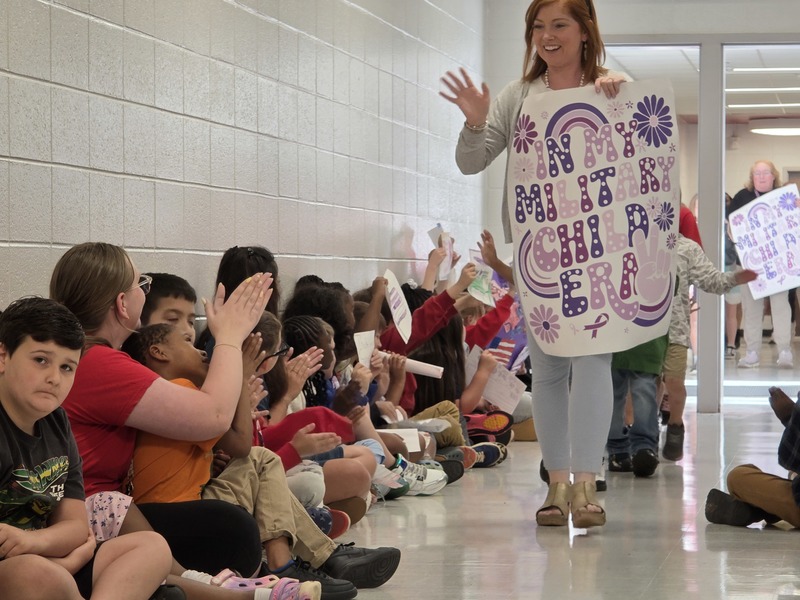 Students and staff walking through the hall in parade.