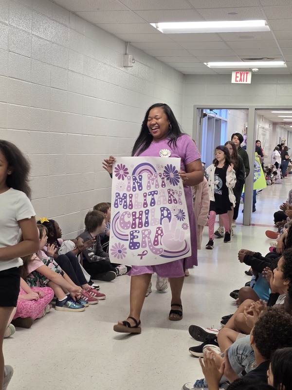 Students and staff walking through the hall in parade.