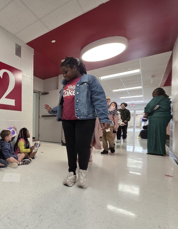 Students and staff walking through the hall in parade.