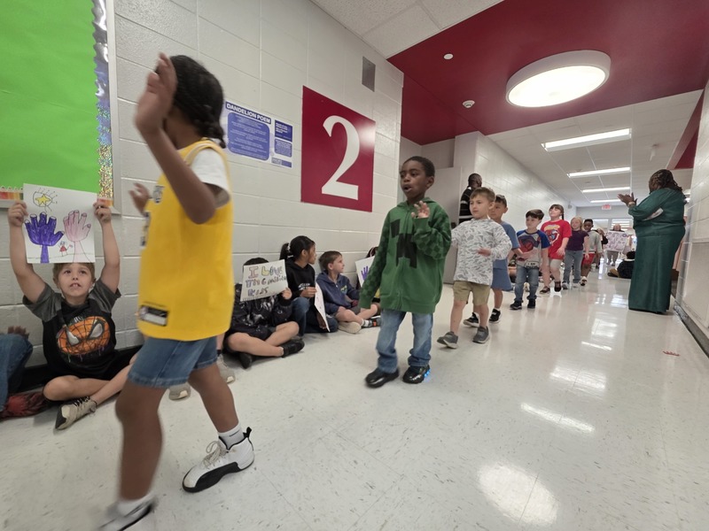 Students and staff walking through the hall in parade.