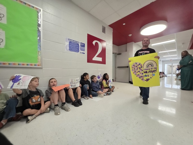 Students and staff walking through the hall in parade.