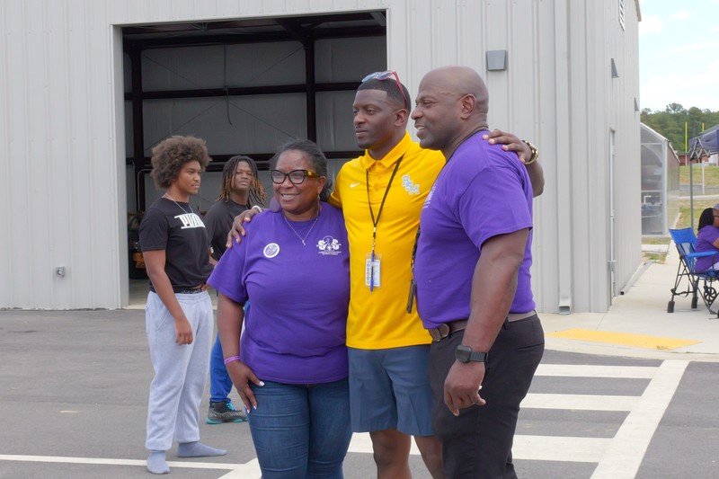 Three people pose for a photo at the Wagener-Salley Purple Up event for military children.
