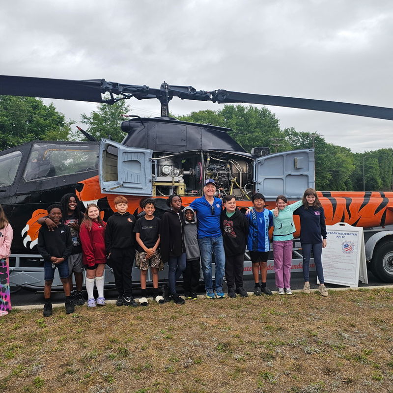 Students standing in front of helicopter with owner.