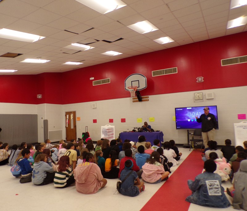 Speakers in front of student audience.