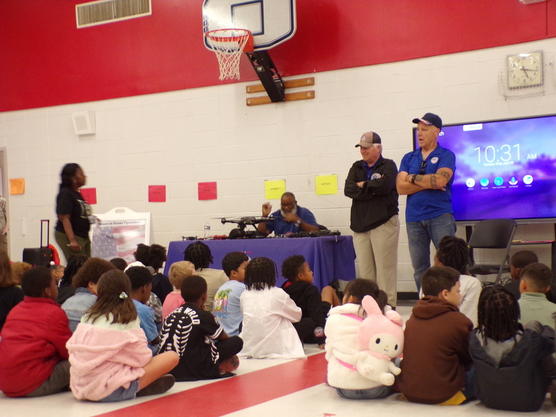 Speakers in front of student audience.