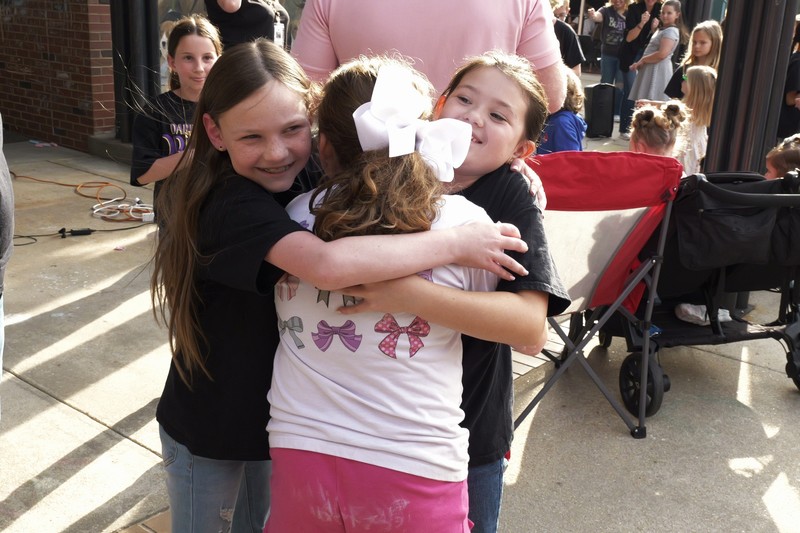 Groupd of young students hugging and smiling.