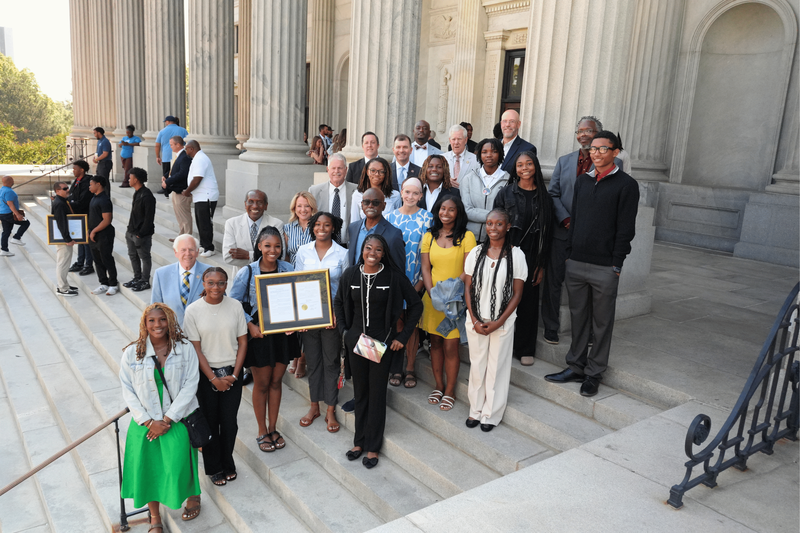 NAHS girls' team posing on steps with the house resolution.