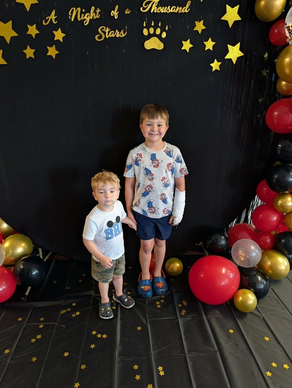 Students posing in front of black backdrop that says "Night of a Thousand Stars".