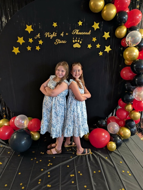 Students posing in front of black backdrop that says "Night of a Thousand Stars".