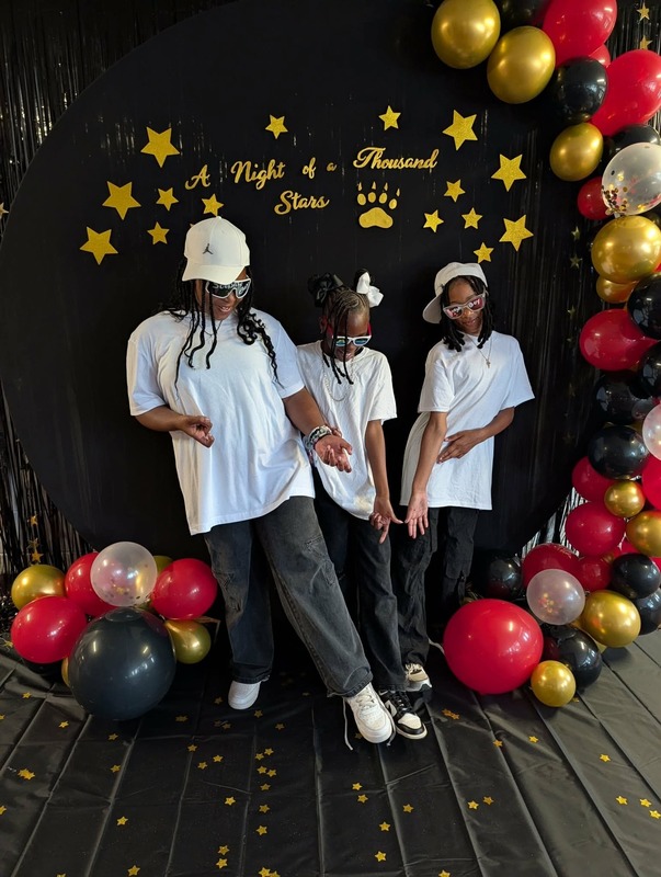 Students posing in front of black backdrop that says "Night of a Thousand Stars".