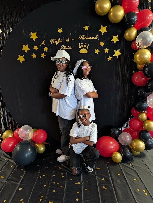 Students posing in front of black backdrop that says "Night of a Thousand Stars".