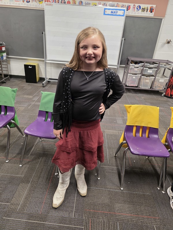 Student standing in front of chair.