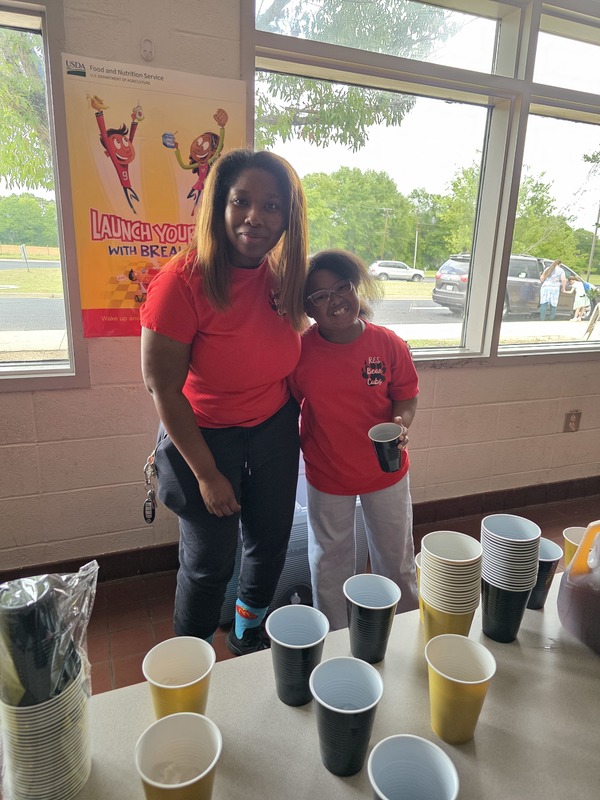 Student and volunteer serving drinks.