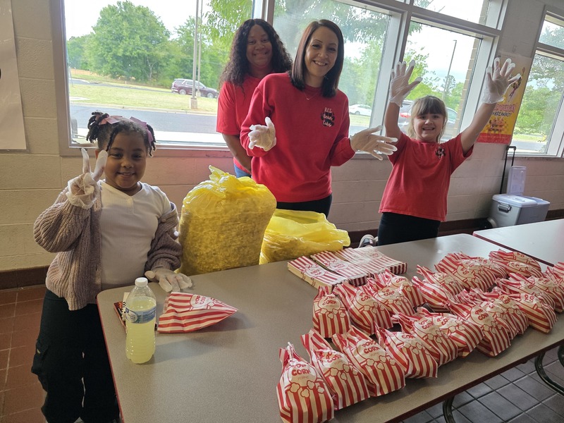 Students and staff serving popcorn.