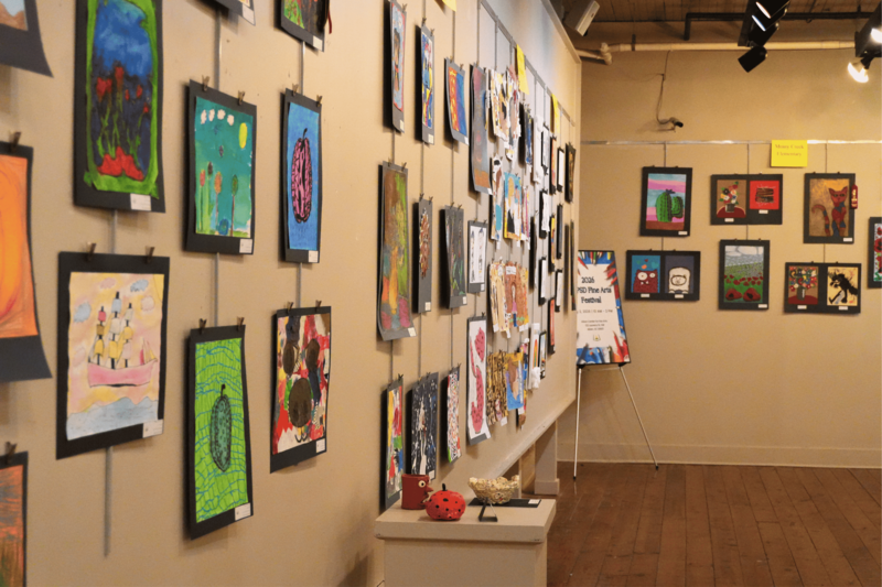 Wall containing multiple art pieces hung on the wall.