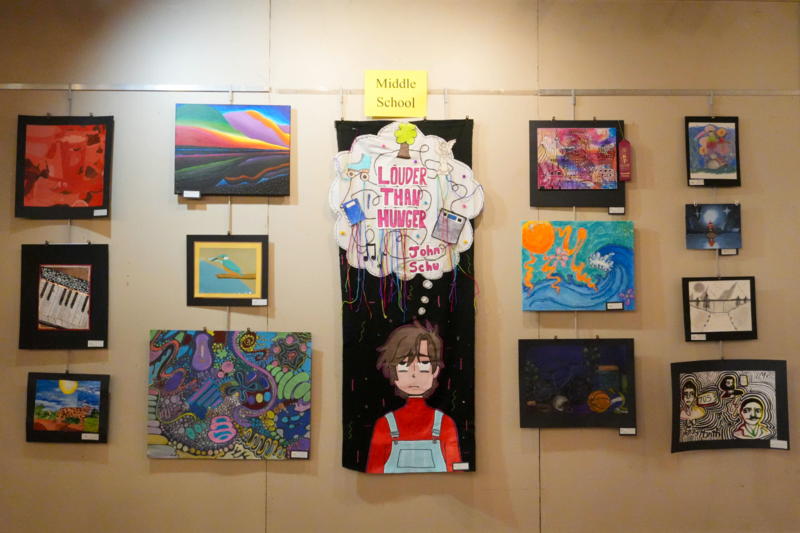 Middle school art pieces hung on wall.