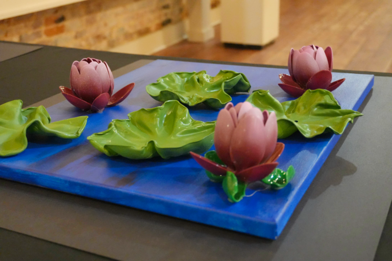 3D art including ceramic lily pads on canvas.