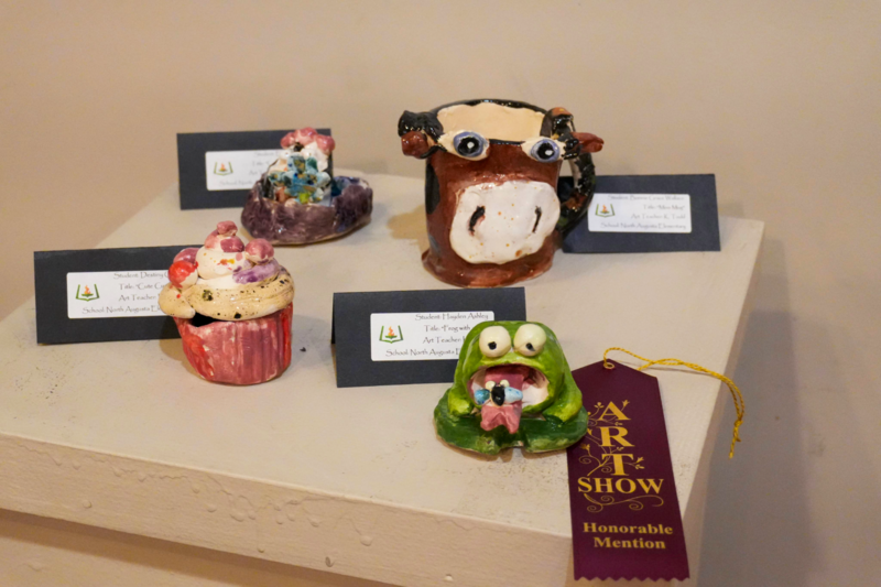 Ceramic art of cupcake, frog, and cow mug.