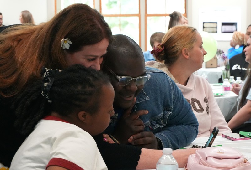 A teacher takes a selfie with two students.