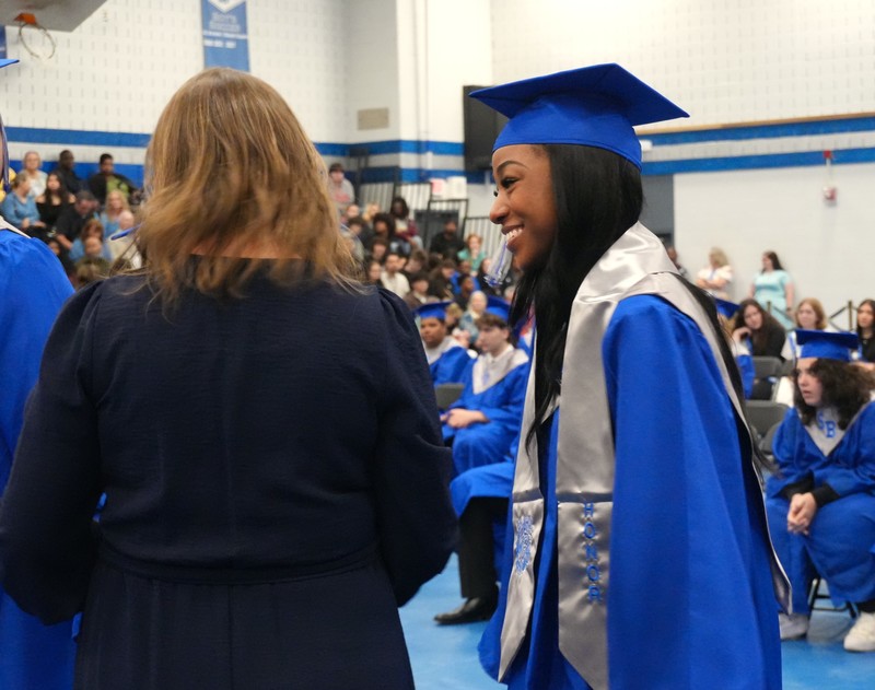 A student smiles after receiving her honors stole.