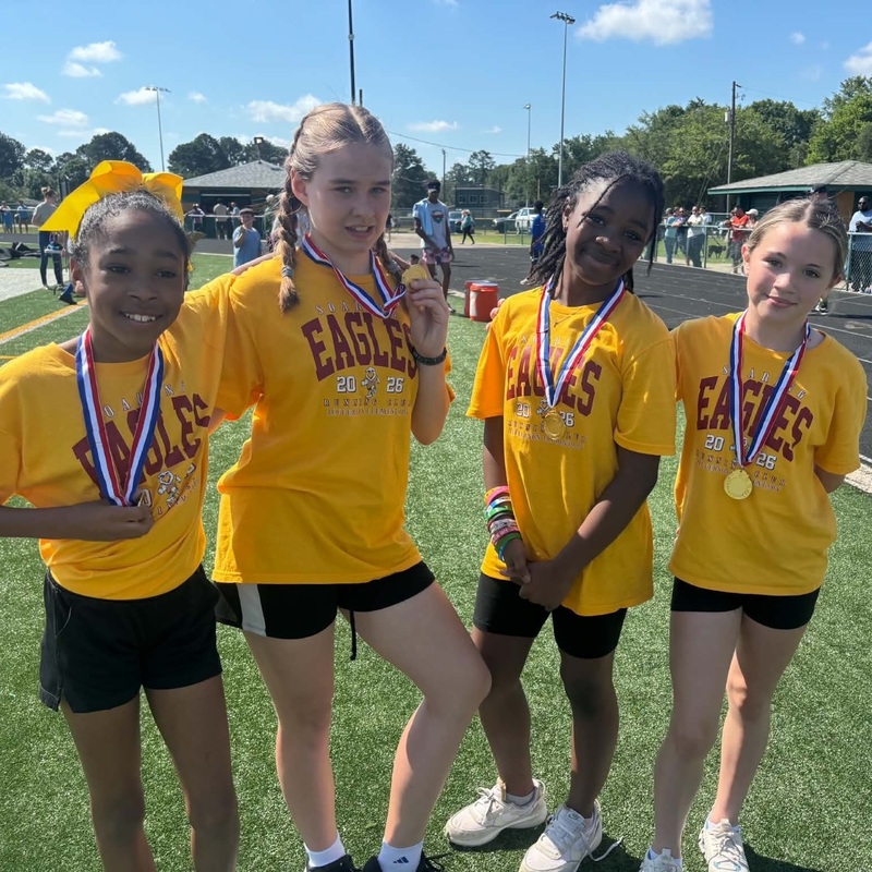 Four fifth grade girls show off the medals they won.
