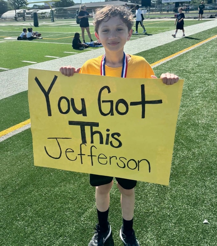 A boy holds a sign that states, "You Got This Jefferson."