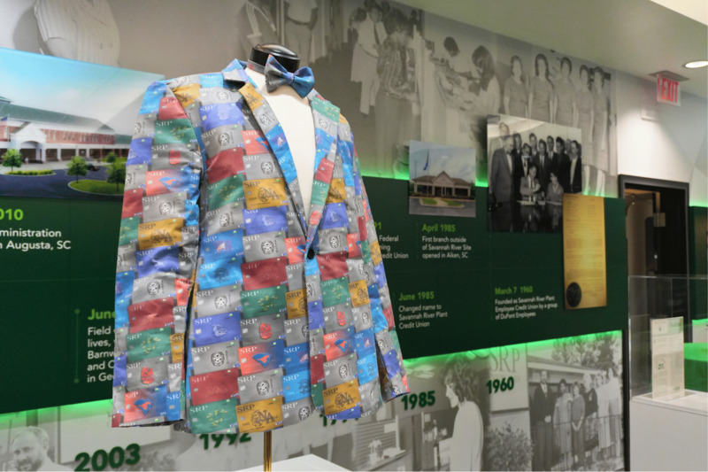 A custom sportcoat is on display featuring debit cards with high school logos and mascots.