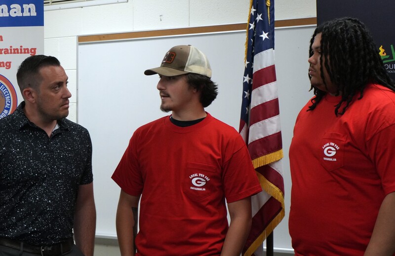 Two students speak with an Ironworkers trade union representative.